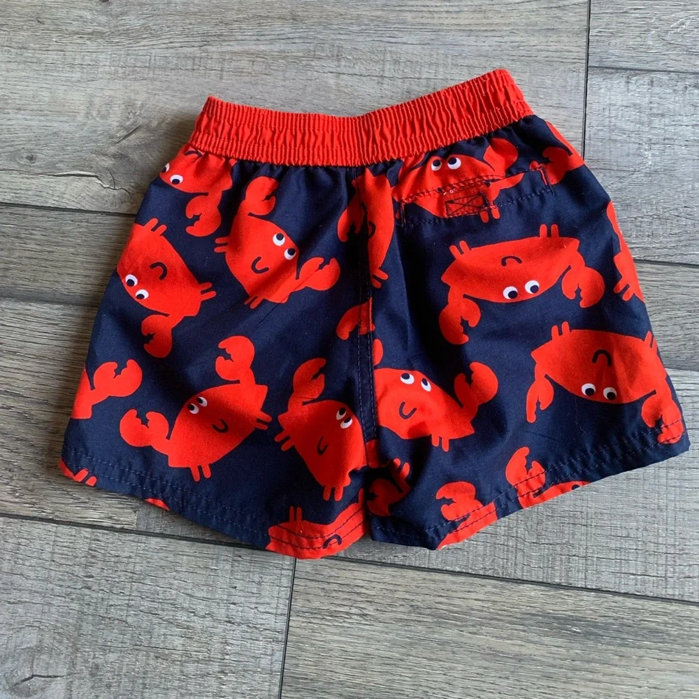 2 Pr. Boys Swim Trunks-Carter’s Crab Swim Trunks and Cat & Jack Pineappl…